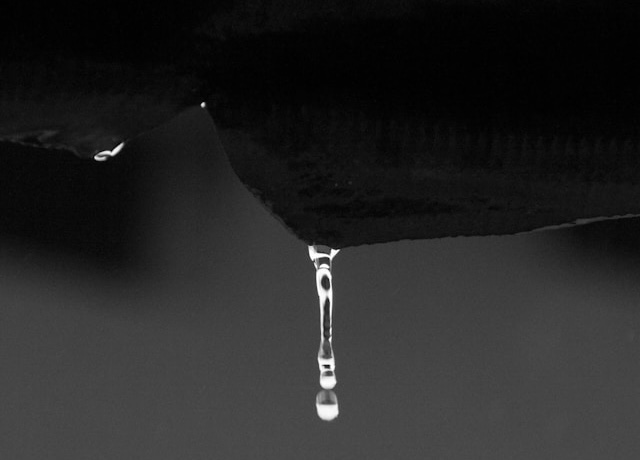 A black and white photograph of a drop of water